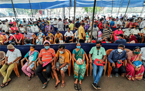 4月26日，众多市民戴着口罩在印度孟买排队等待接种新冠疫苗。新华社发
